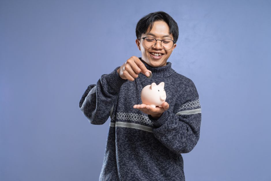 young korean person saving money piggy bank