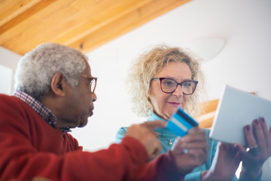 senior couple checking bank savings on tablet