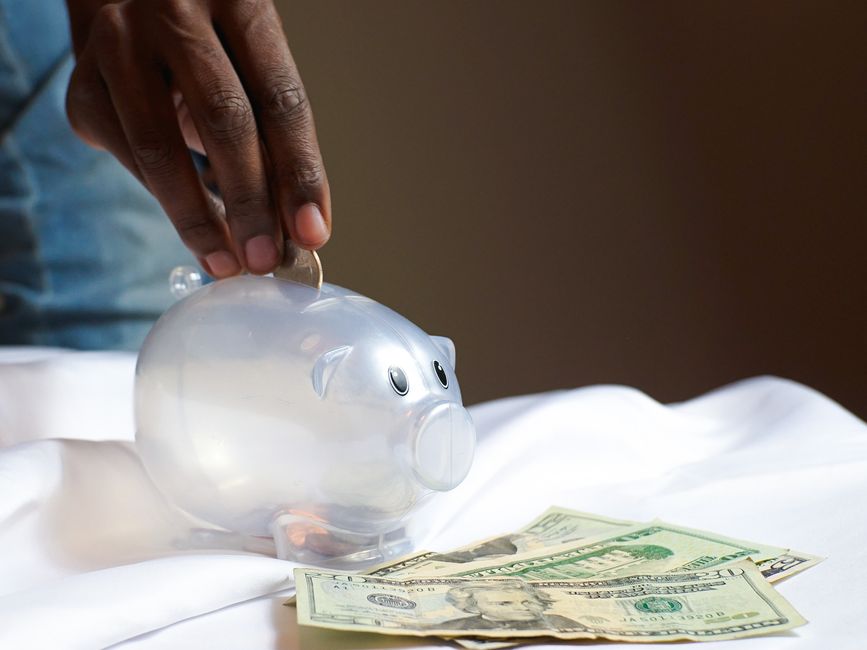 parents giving money to child piggy bank