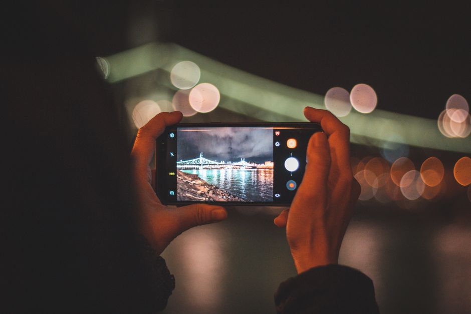 hands selecting photos on smartphone screen
