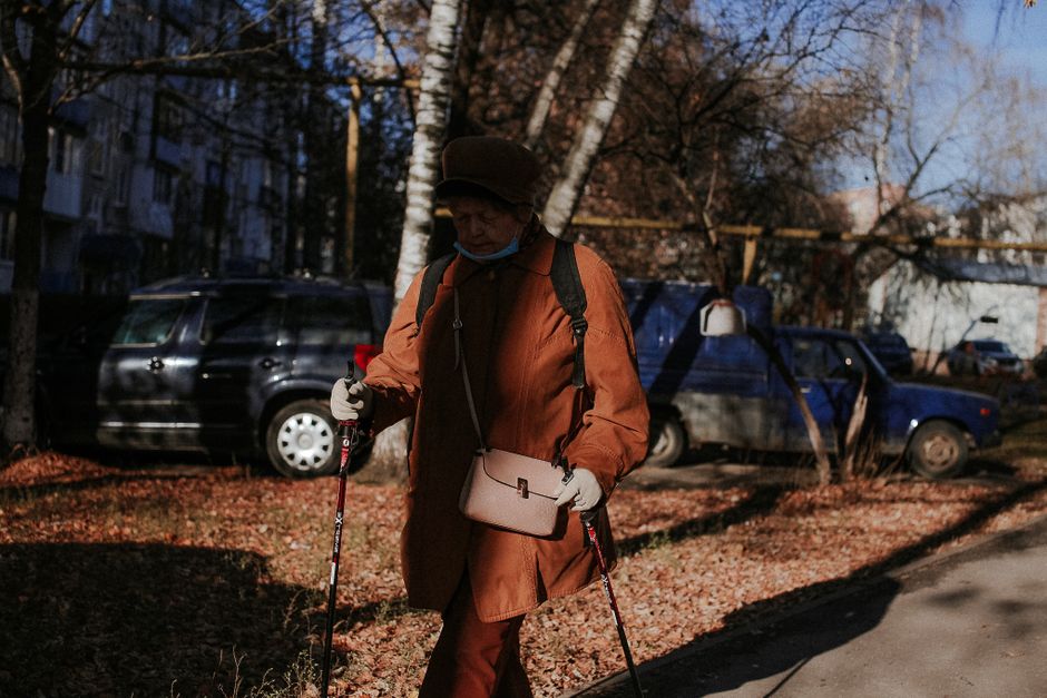 senior woman walking outdoors sunlight