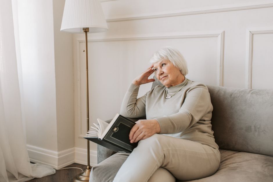 senior woman reading book at home