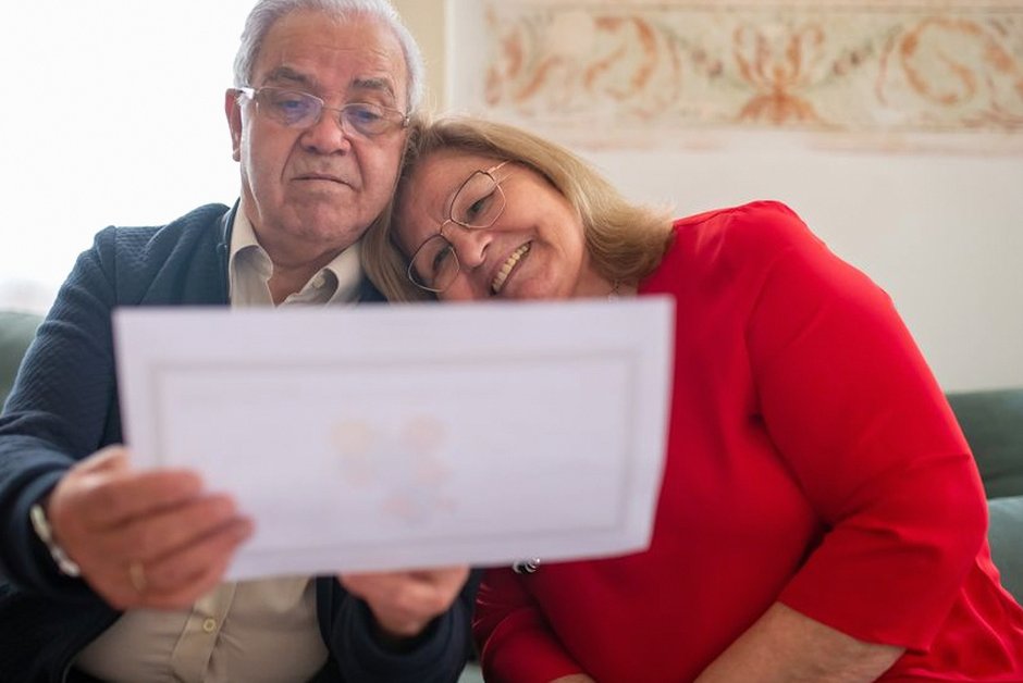 elderly korean couple reviewing documents at home