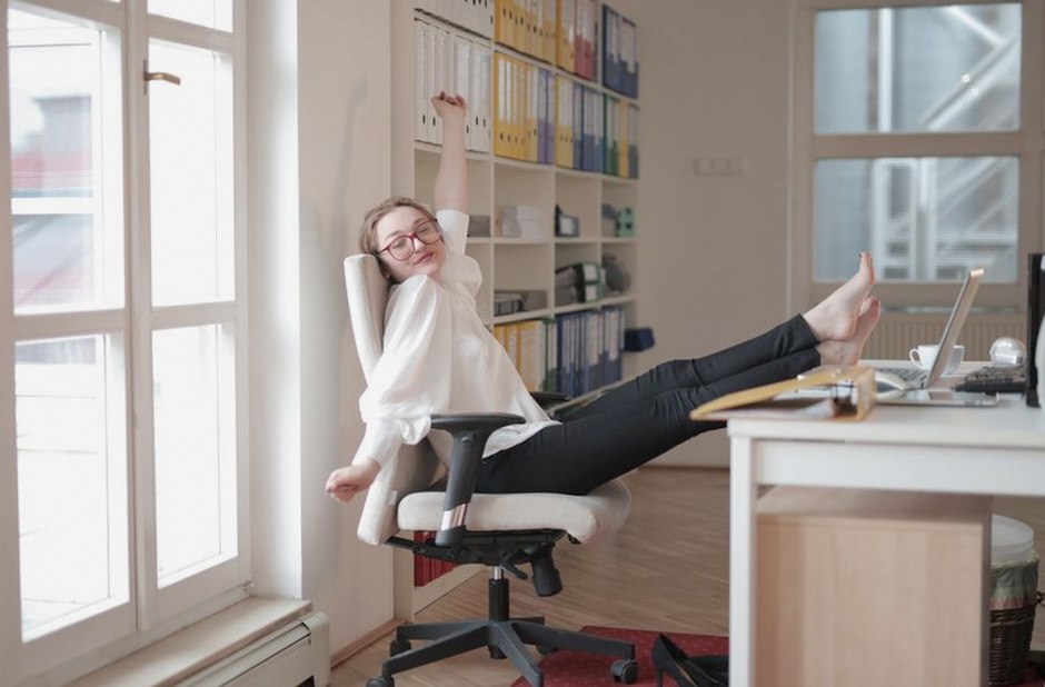 person sitting at desk stretching legs office