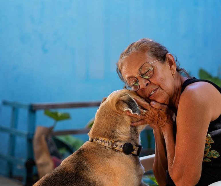 elderly woman with small dog smiling