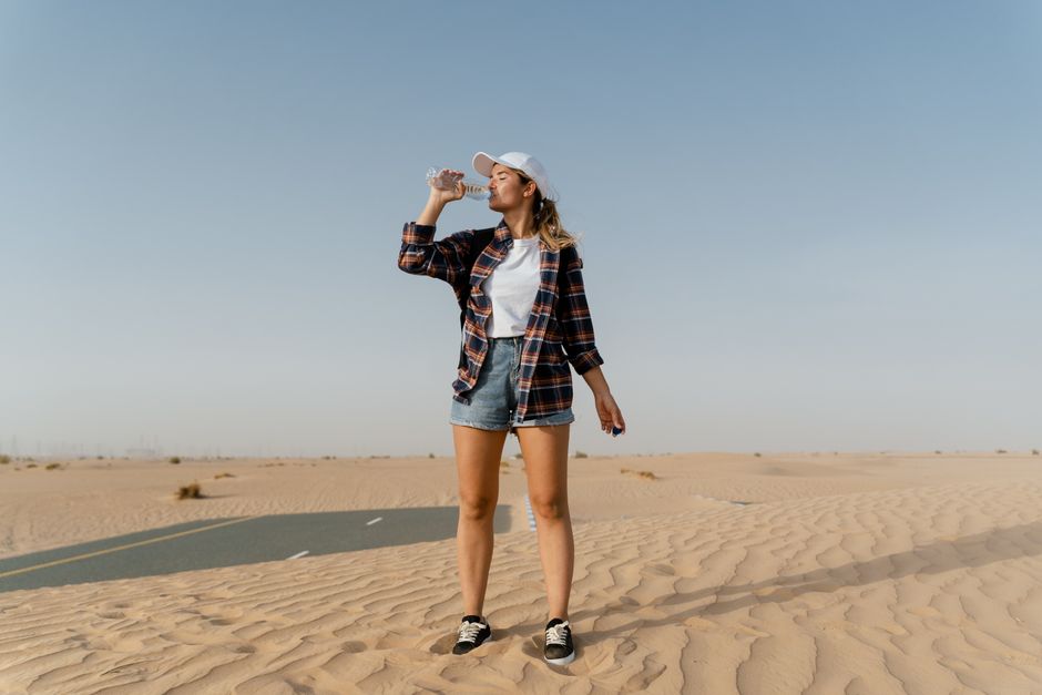 person drinking water in summer heat