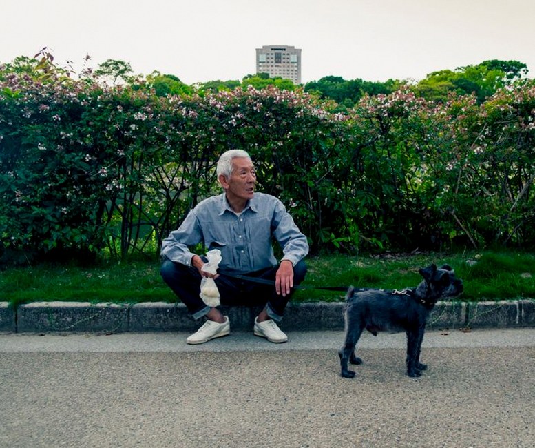 senior man walking dog in park
