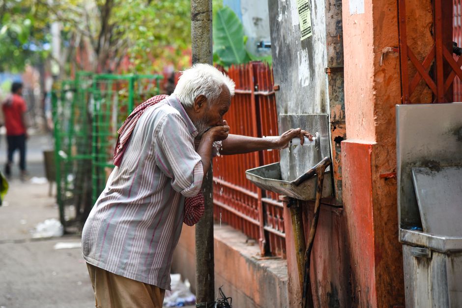 senior man drinking water hot summer day