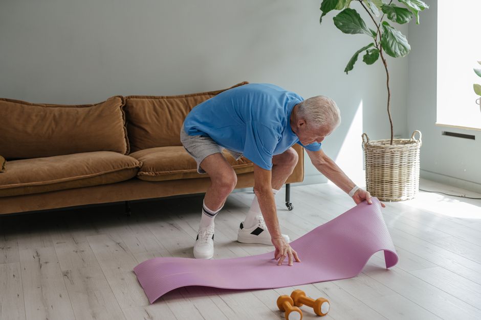 senior man stretching back on yoga mat