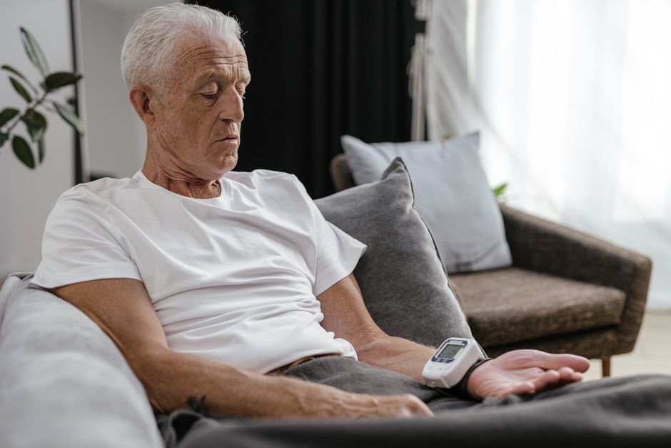 senior man checking blood pressure at home