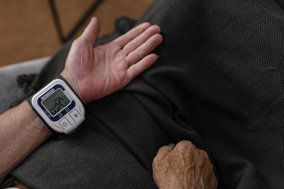 elderly person measuring blood pressure at home