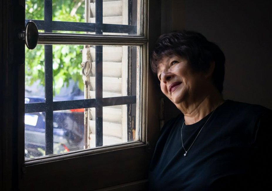 elderly korean woman looking out window apartment
