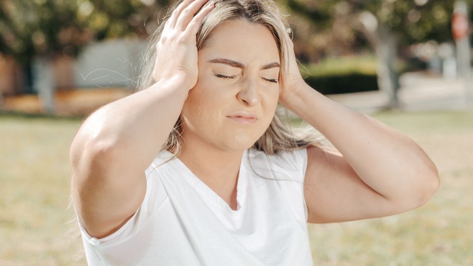 dizzy person holding head feeling faint