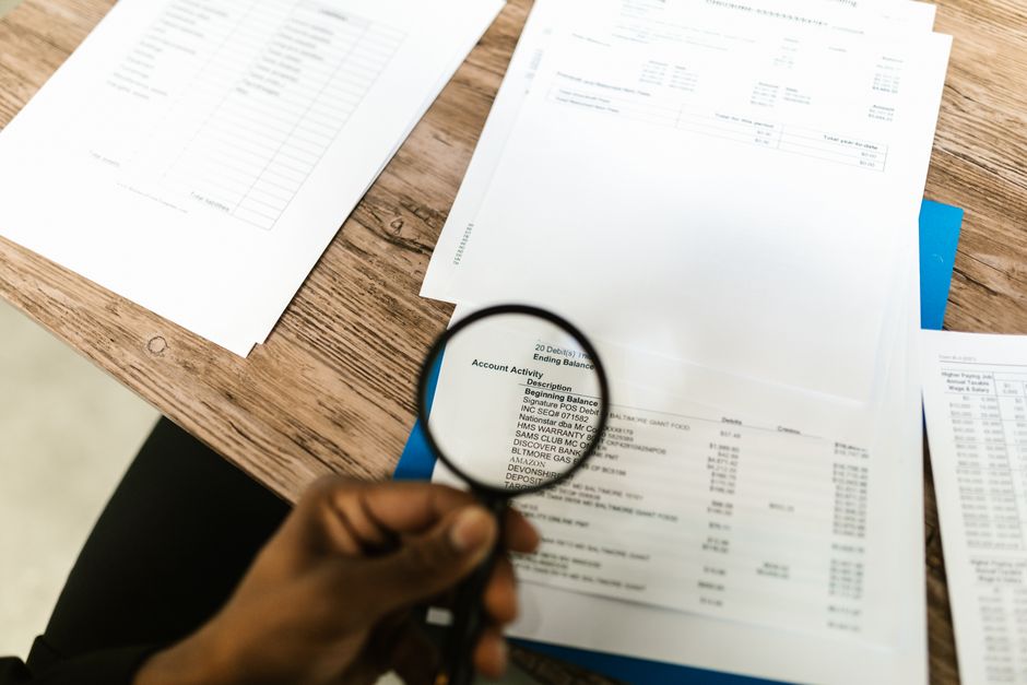 senior reviewing documents with magnifying glass