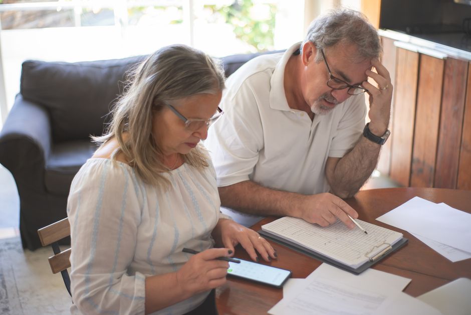 elderly couple planning budget notebook
