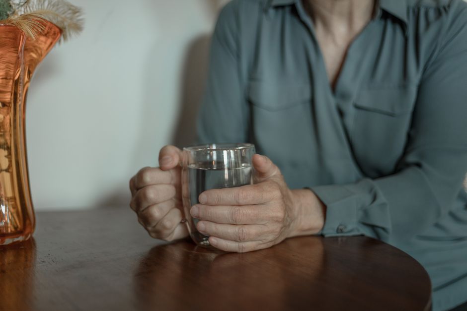 elderly person drinking warm water at home