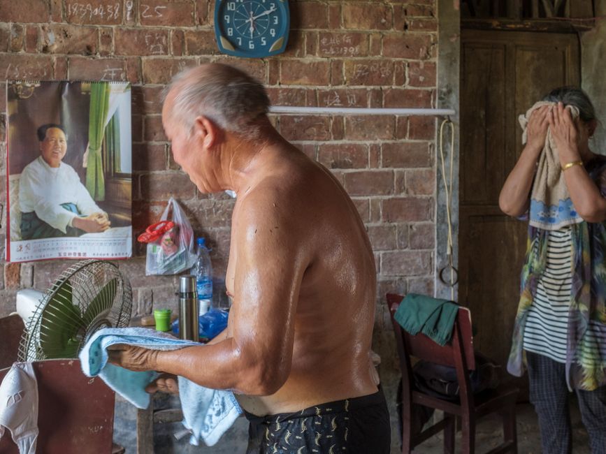elderly couple resting indoors electric fan