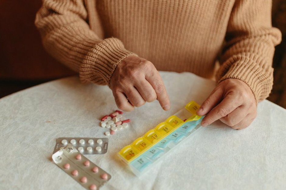 elderly person organizing medication pills