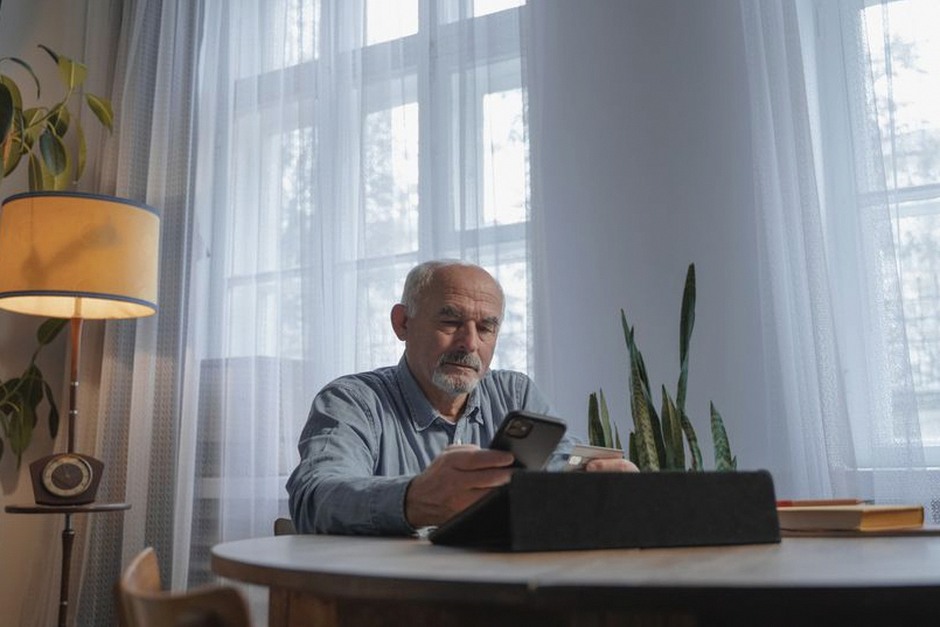 senior citizen using smartphone at home