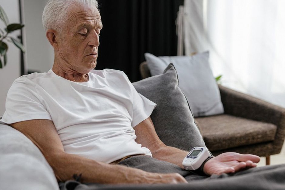 elderly korean man checking blood pressure at home