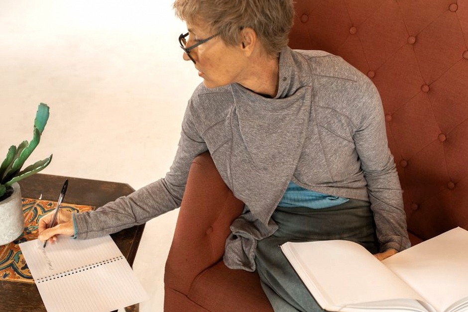 senior woman writing journal at home