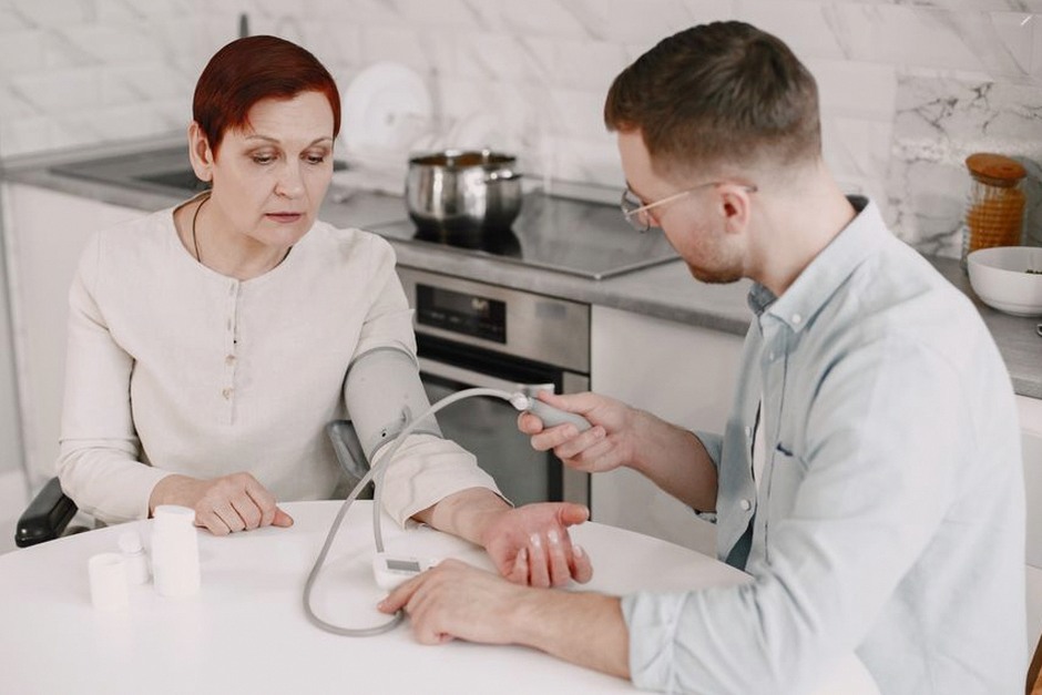 doctor checking blood pressure elderly patient