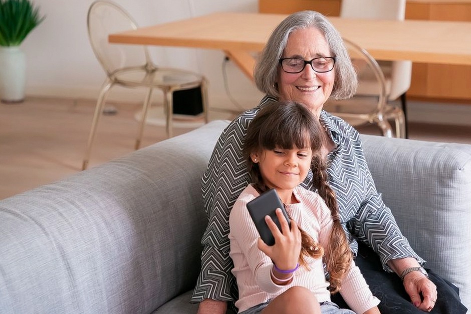 grandparent and grandchild looking at smartphone together