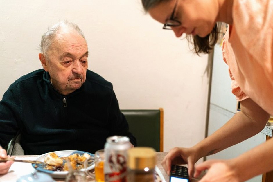family helping senior with phone settings