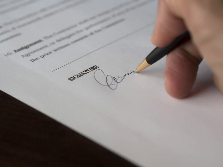 signing legal document with pen