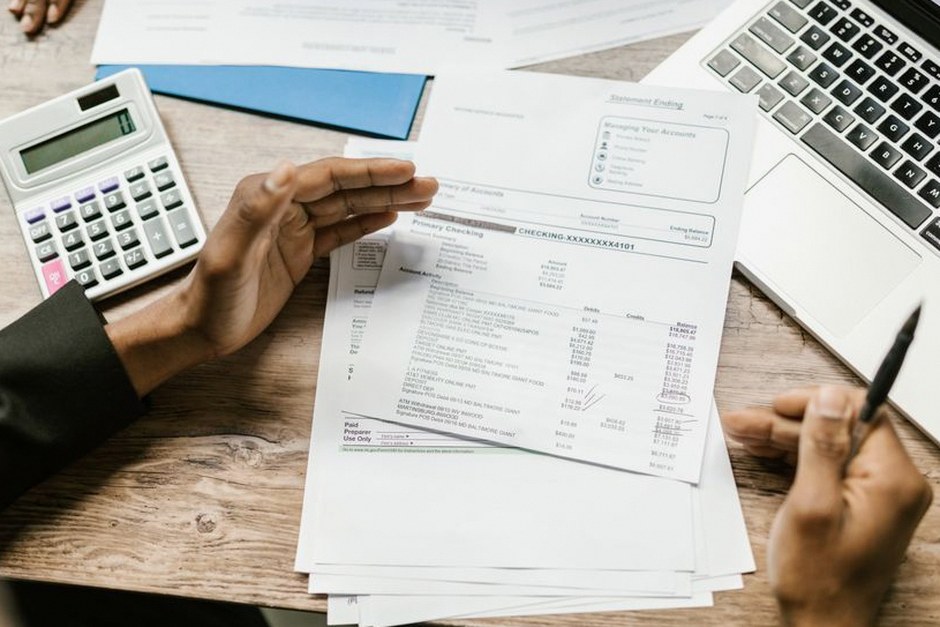 person reviewing bank account statement laptop
