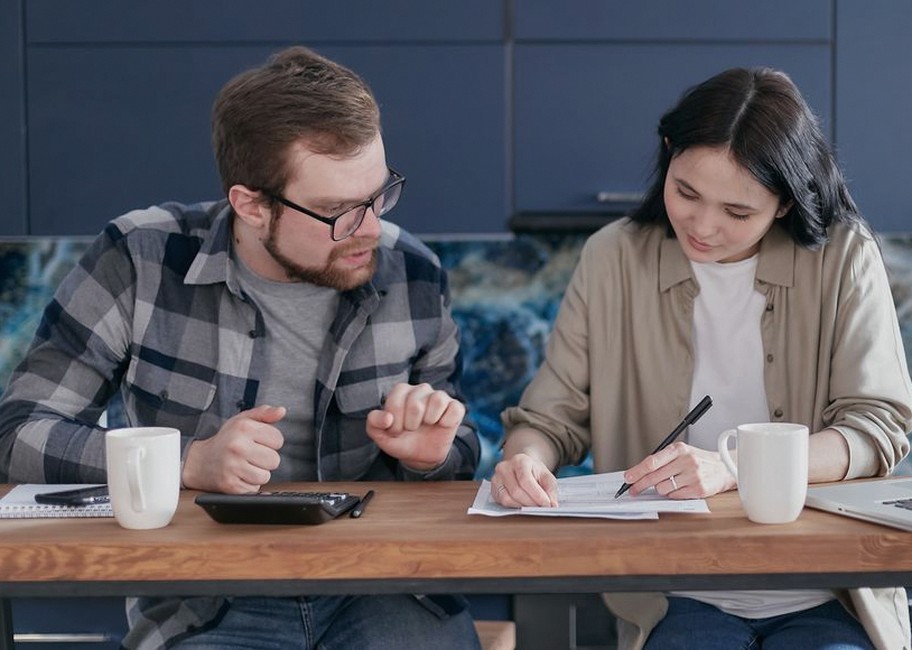 young couple checking finances laptop