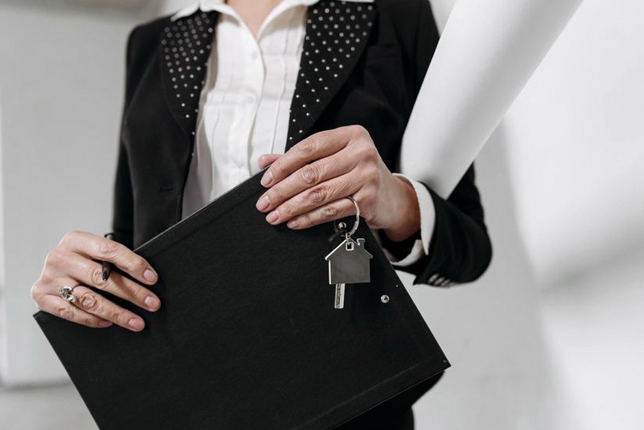 hands holding house key document