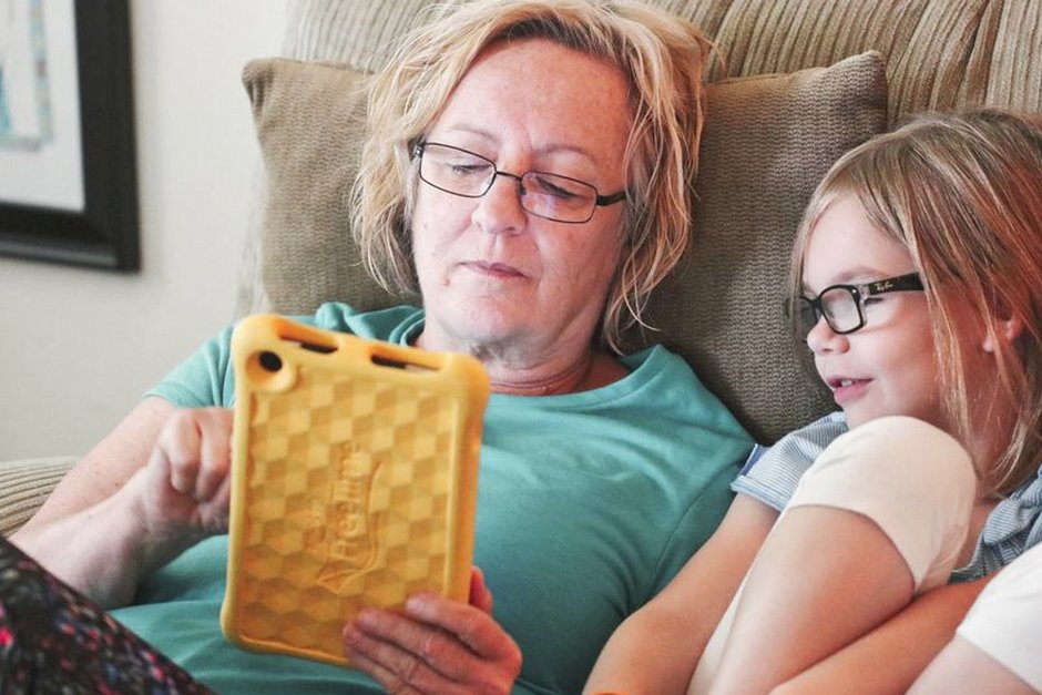 elderly parent and adult child setting up device together