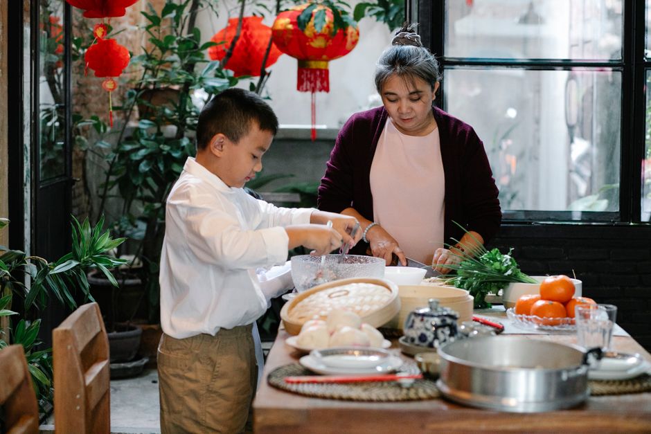 korean family preparing holiday food kitchen