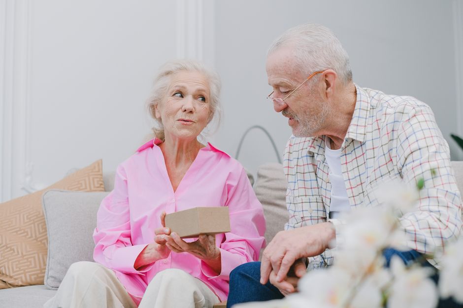 senior couple opening gift box at home