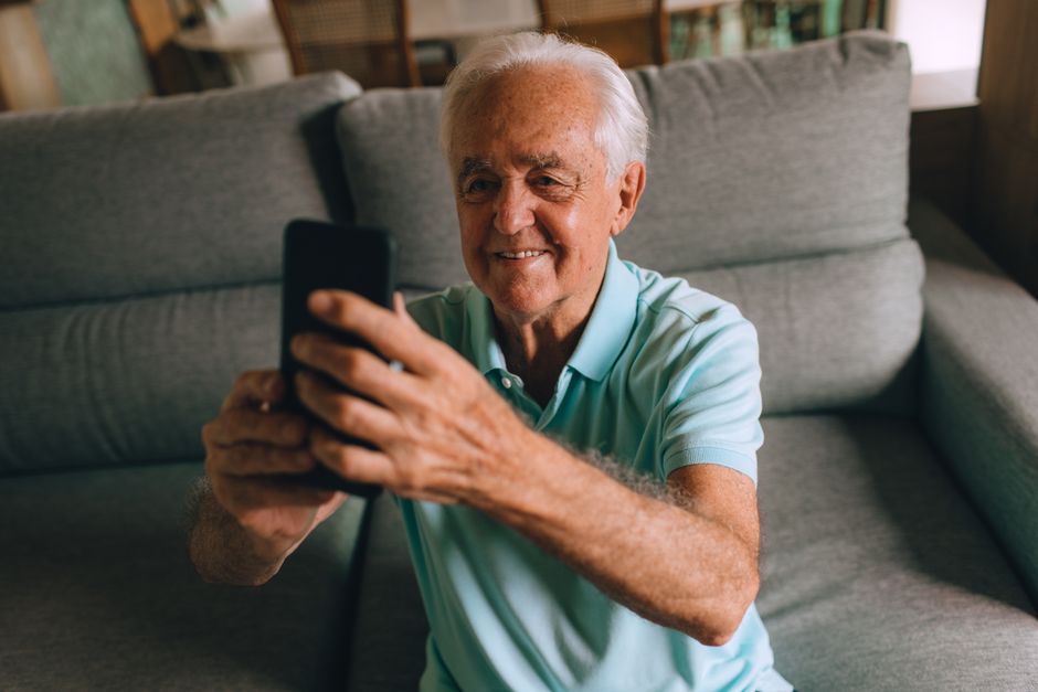 elderly person using smartphone donation app