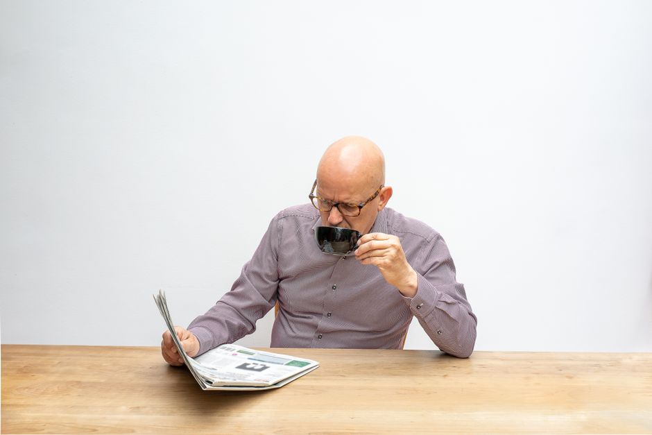 elderly man reading newspaper morning routine