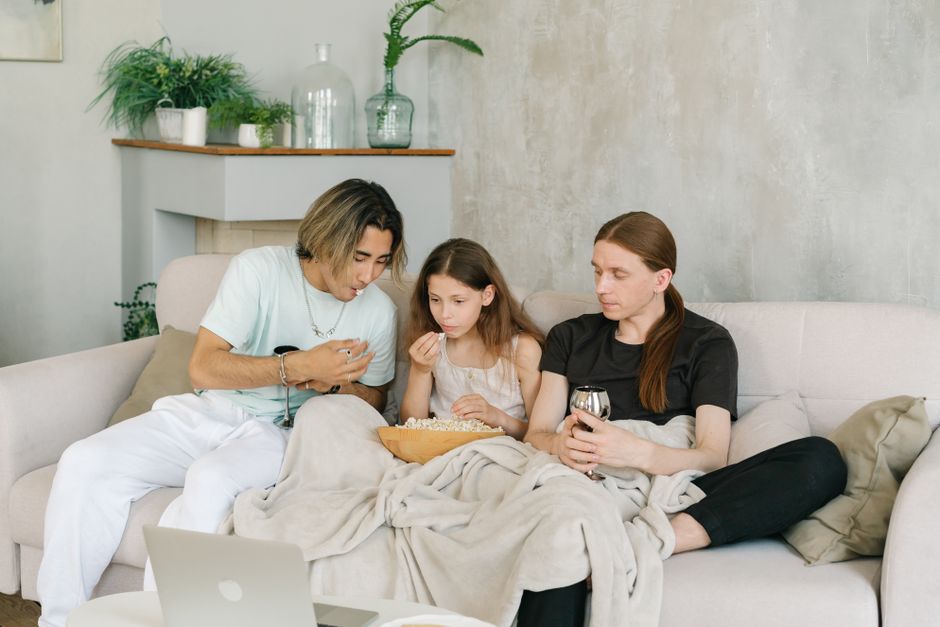 family watching movie together living room blanket
