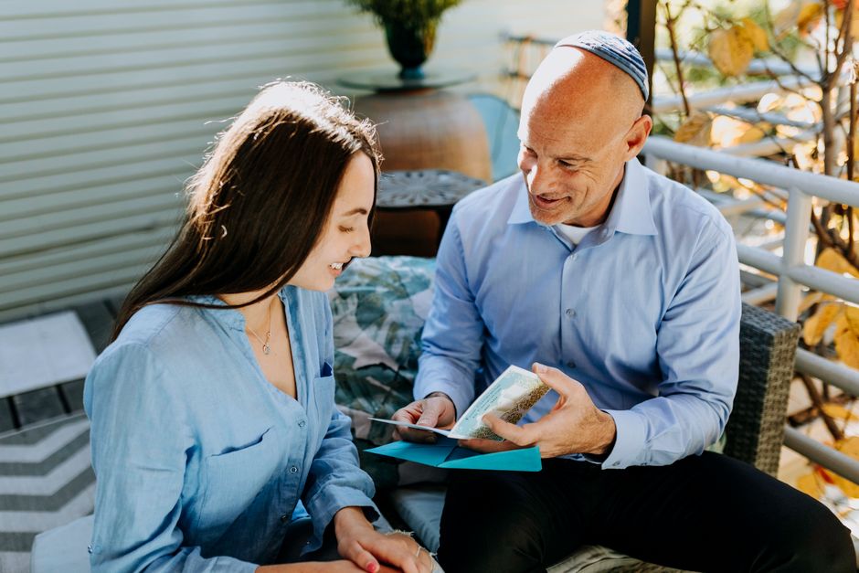 two people reading letter together smiling