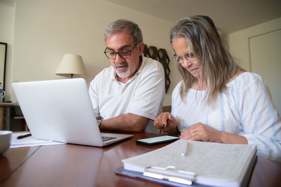 elderly couple discussing paperwork at home