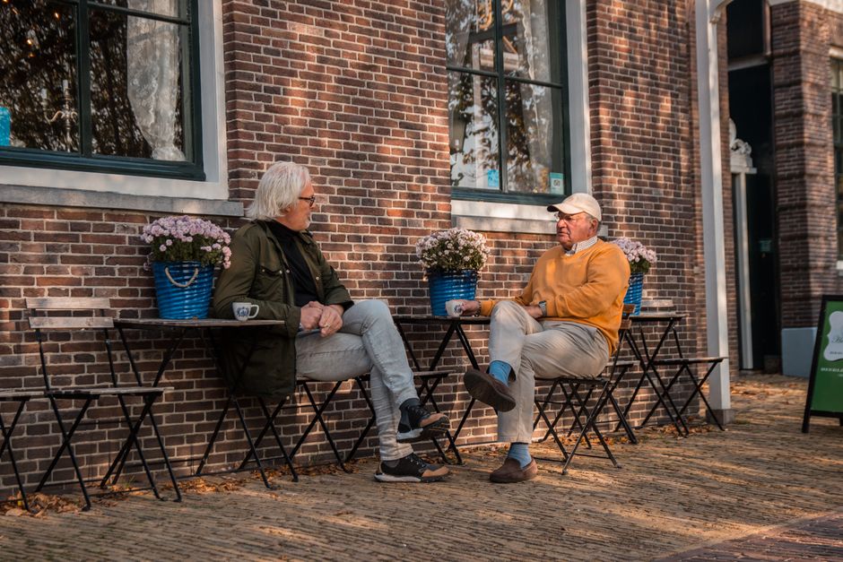 elderly friends talking coffee outdoors