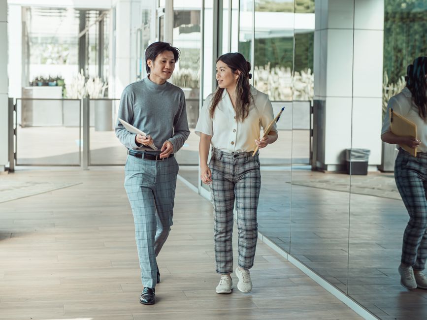 colleagues walking talking workplace hallway