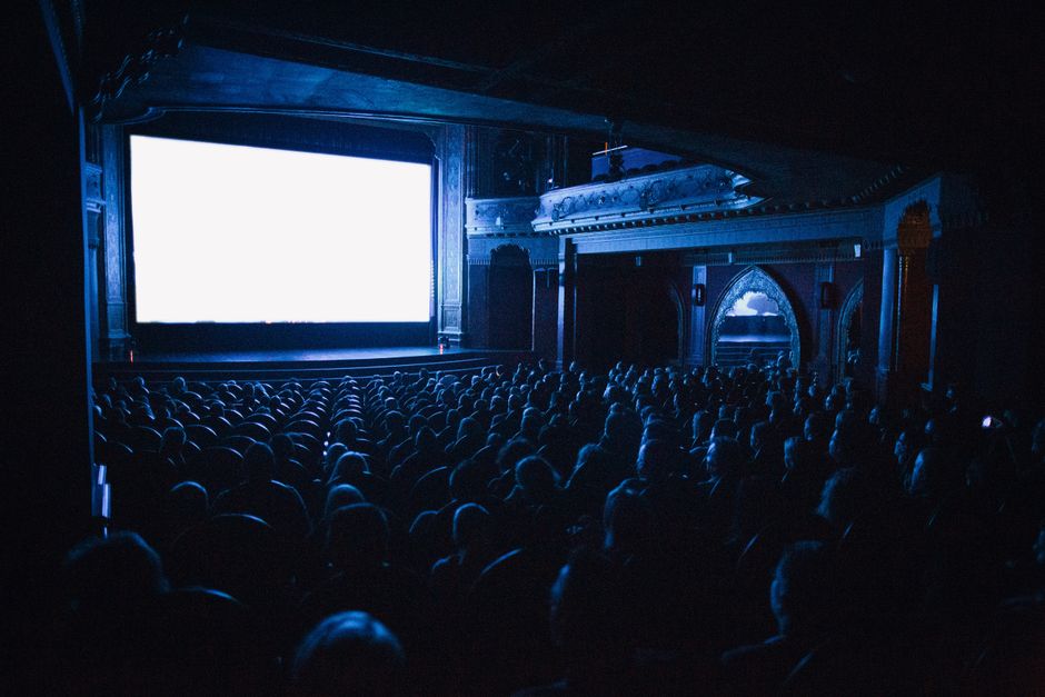 people watching movie in dark theater